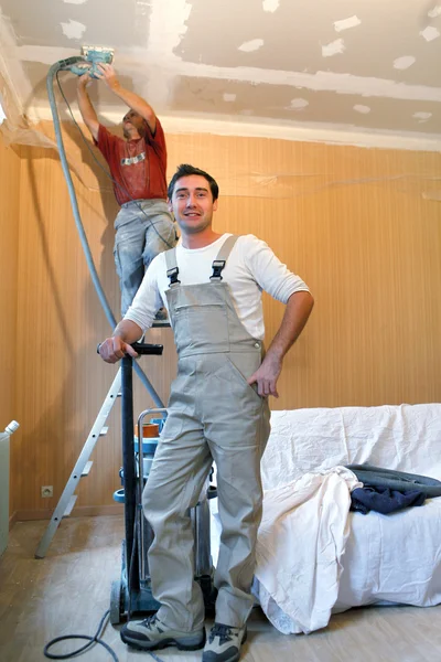 Due decoratori che utilizzano levigatrice — Foto Stock
