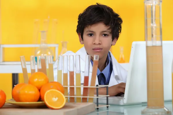Menino analisando laranjas no laboratório — Fotografia de Stock