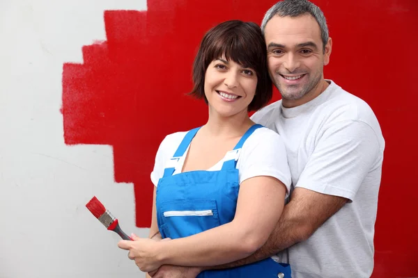 Couple painting a wall in red — Stock Photo, Image