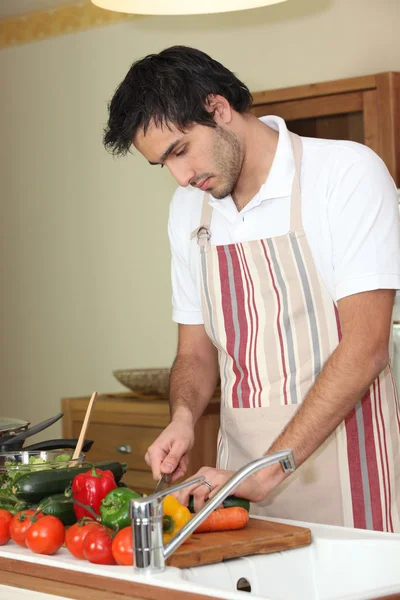Mladý muž přípravy zeleniny — Stock fotografie