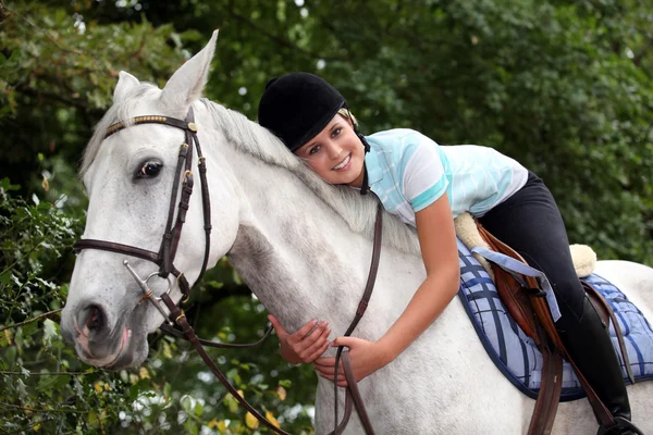 Молодая женщина обнимает свою лошадь — стоковое фото