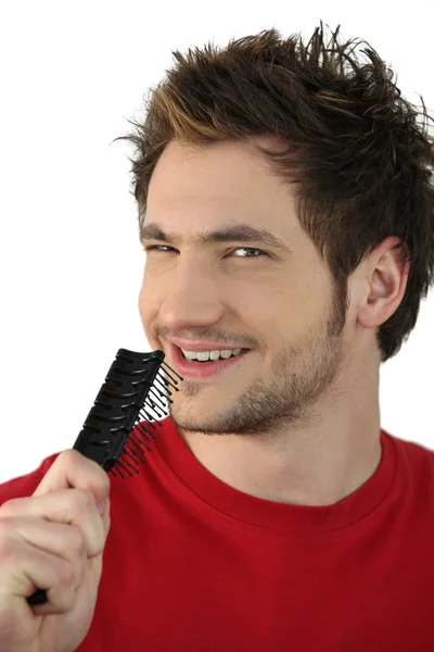 Young man singing into a hairbrush — Stock Photo, Image