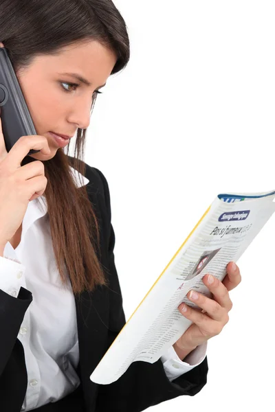 Woman calling an advert in a magazine — Stock Photo, Image