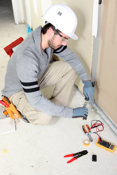 Чоловік ремонтує електропроводку будинку — стокове фото