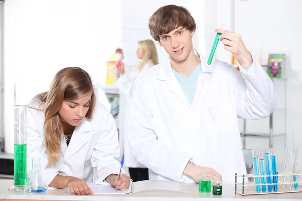 Estudiantes en una clase de química con tubos de ensayo y otros equipos de laboratorio —  Fotos de Stock