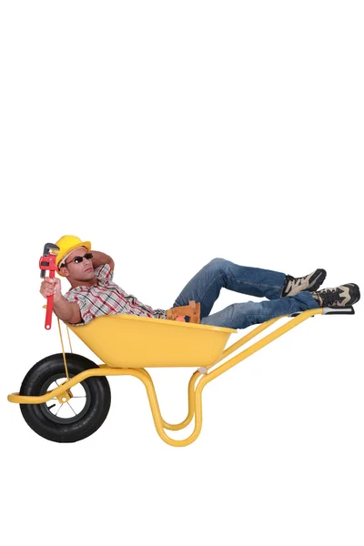 Unmotivated laborer resting in a wheelbarrow — Stock Photo, Image