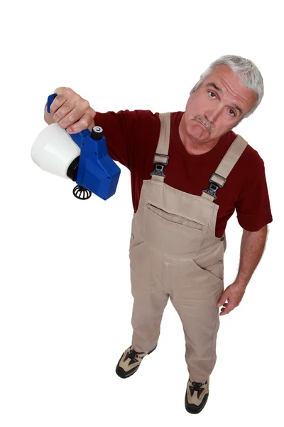 Handwerker hält leeren Sprayer in der Hand und sieht enttäuscht aus — Stockfoto