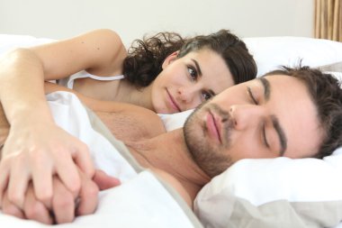 Woman watching her husband sleeping clipart