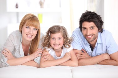 Family laying on bed together clipart