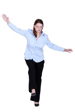 Woman pretending to walk on tight-rope clipart
