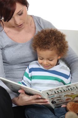 Woman and child reading a book clipart