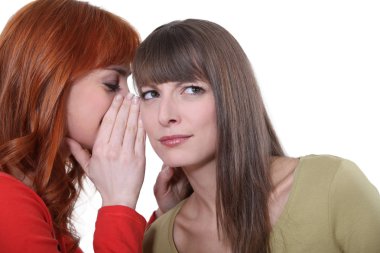 Woman whispering into her friend's ear clipart