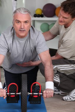 Middle-aged man with personal trainer clipart