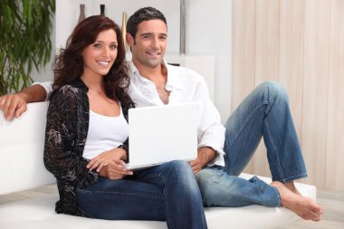 A 35 years old couple sitting on a couch clipart