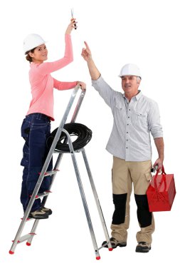 Experienced tradesman pointing to his assistant clipart