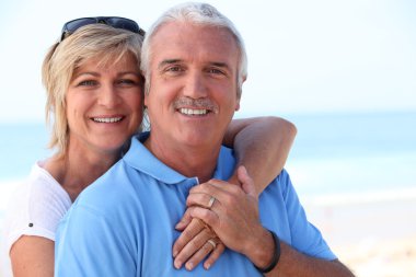 Middle aged couple at the beach. clipart