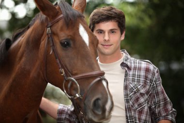 Young man and a horse in the forest clipart