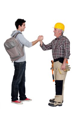 Tradesman making a pact with a young man clipart