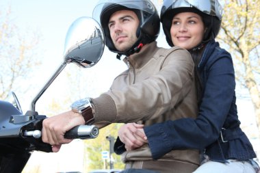 Couple riding a scooter clipart