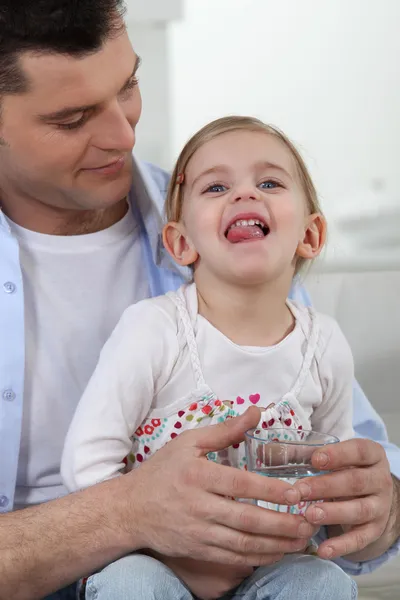 Отец давал девочке выпить воды — стоковое фото