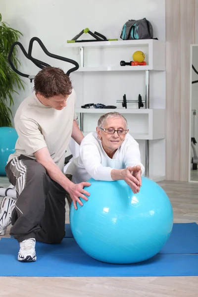 Treinador de fitness dando um treinamento pessoal para uma senhora idosa — Fotografia de Stock