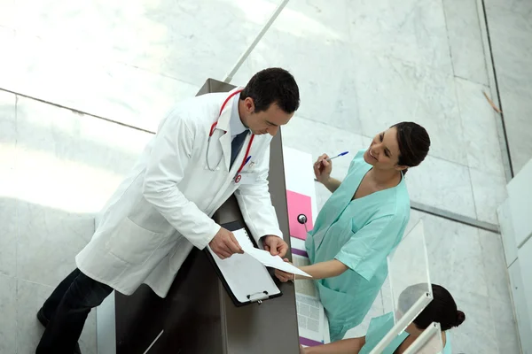 Secretário médico mostrando registro ao médico — Fotografia de Stock