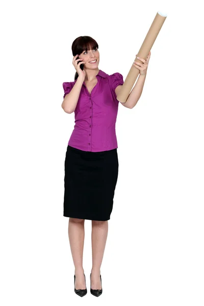 Frau am Telefon und in der Hand eine Pappröhre — Stockfoto