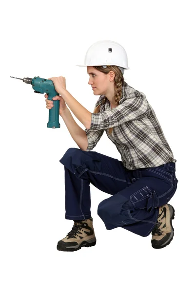 Woman knelt with drill — Stock Photo, Image