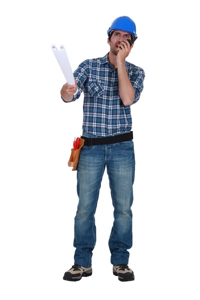 Workman with plans and a walkie talkie — Stock Photo, Image