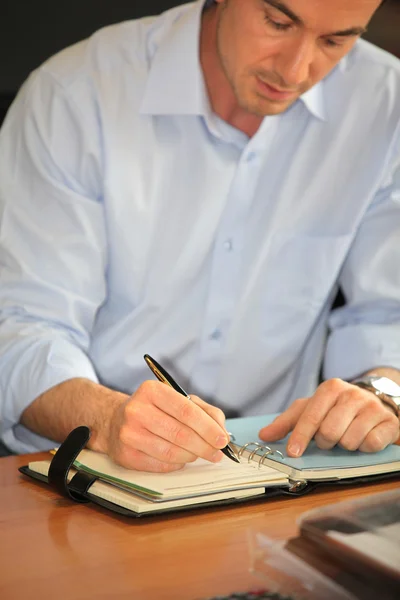 Man schrijven in een persoonlijke organizer — Stockfoto