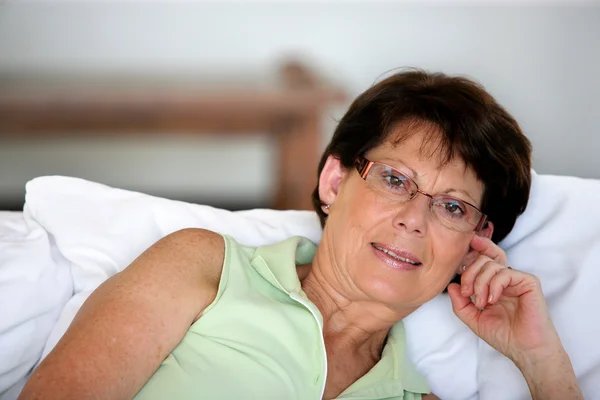 退休的妇女支撑着一些缓冲垫 — 图库照片