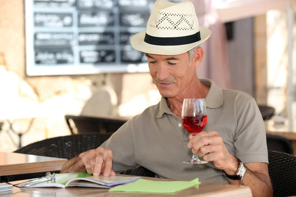 Senior on vacation drinking fresh wine in a restaurant — Stock Photo, Image
