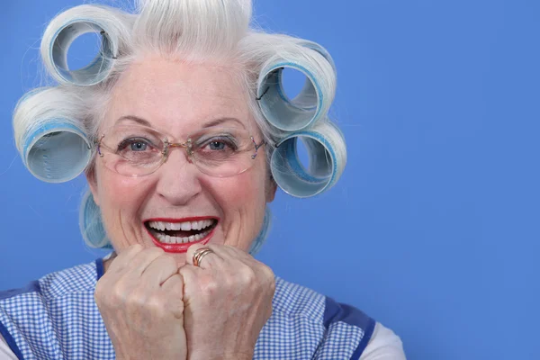 Senior woman with curlers in her hair laughing — Stock Photo, Image