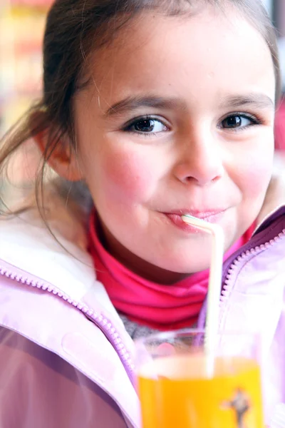 Jong meisje drinken van een glas sinaasappelsap — Stockfoto