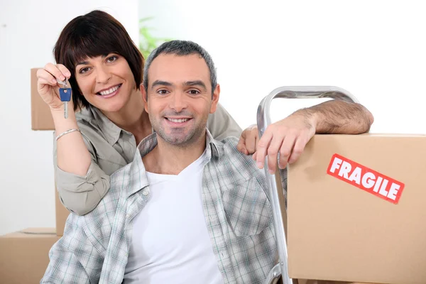 Casal movendo-se para casa nova com chaves de porta e caixas marcadas frágil — Fotografia de Stock