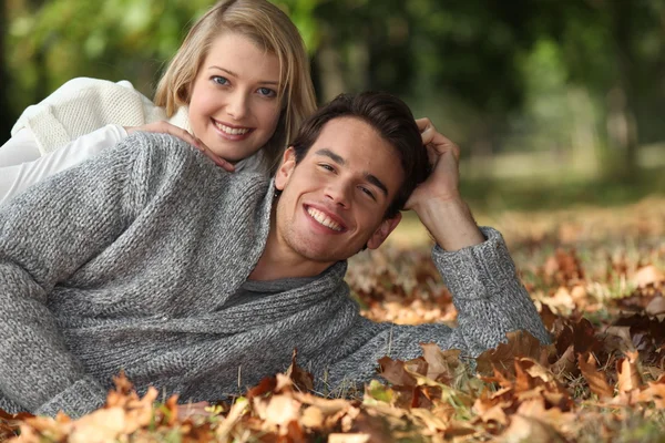 Paar liggen in de bladeren — Stockfoto
