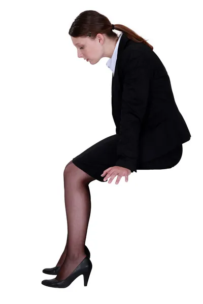 Empresária sentada no perfil com as pernas penduradas — Fotografia de Stock