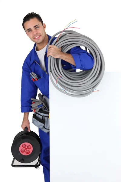Electricista con cable de extensión preparado por cartel — Foto de Stock