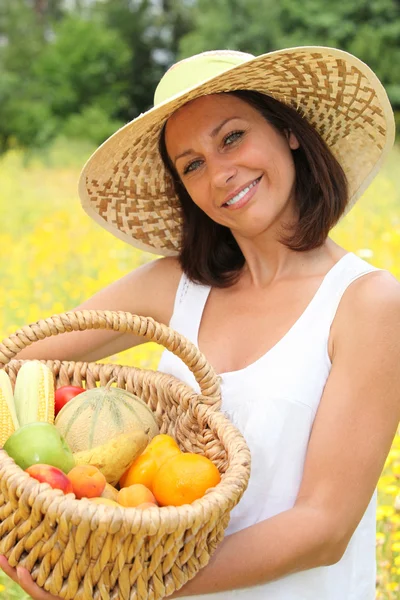 Femme tenant un panier de fruits et légumes — Photo