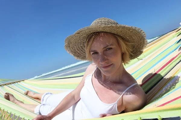 Blond kobieta relaks na plaży w hamaku — Zdjęcie stockowe
