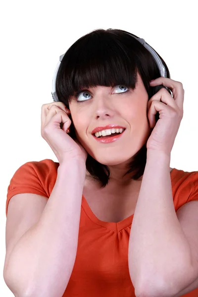 Morena ouvindo música através de fones de ouvido — Fotografia de Stock