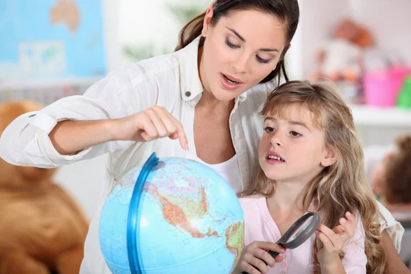 小さな女の子のお母さんと地理を学習 — ストック写真