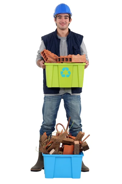 Albañil joven sosteniendo bañera de reciclaje — Foto de Stock