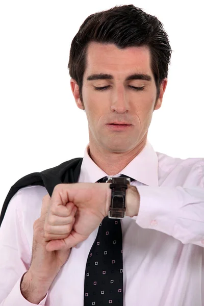 Zakenman met vacht over schouder raadpleging zijn horloge — Stockfoto