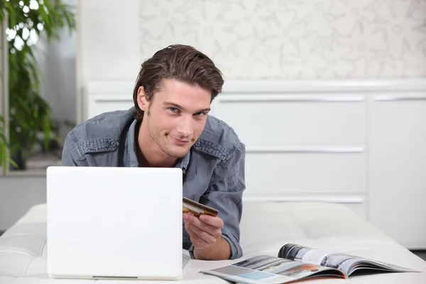 Uomo che utilizza una carta di credito per acquistare online — Foto Stock