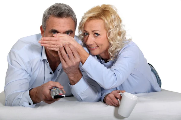 Mulher cobrindo os olhos de seu marido durante um filme assustador — Fotografia de Stock