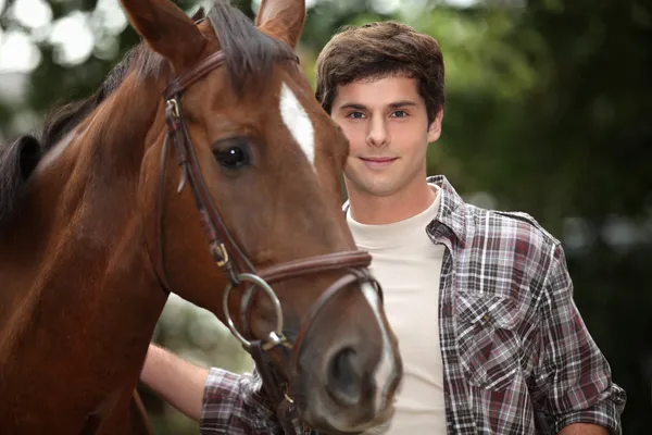 Fiatal férfi és egy ló az erdő — Stock Fotó