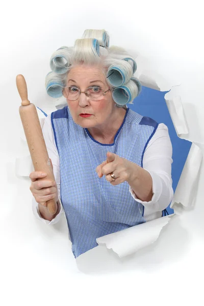 Grandma with hair curlers threatening someone with rolling pin — Stock Photo, Image