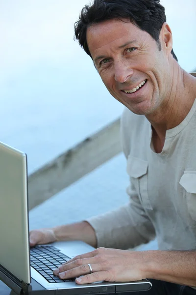 Чоловік сидів на відкритому повітрі з ноутбуком — стокове фото