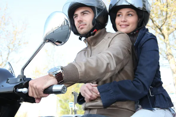 Casal montando uma scooter — Fotografia de Stock